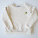 Organically sourced, uncolored toddler's pullover with a delicate, eco-friendly embroidered lime motif, proudly made in the USA, from Colorful Bunch's sustainable kids' apparel line.