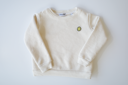 Organically sourced, uncolored toddler's pullover with a delicate, eco-friendly embroidered lime motif, proudly made in the USA, from Colorful Bunch's sustainable kids' apparel line.