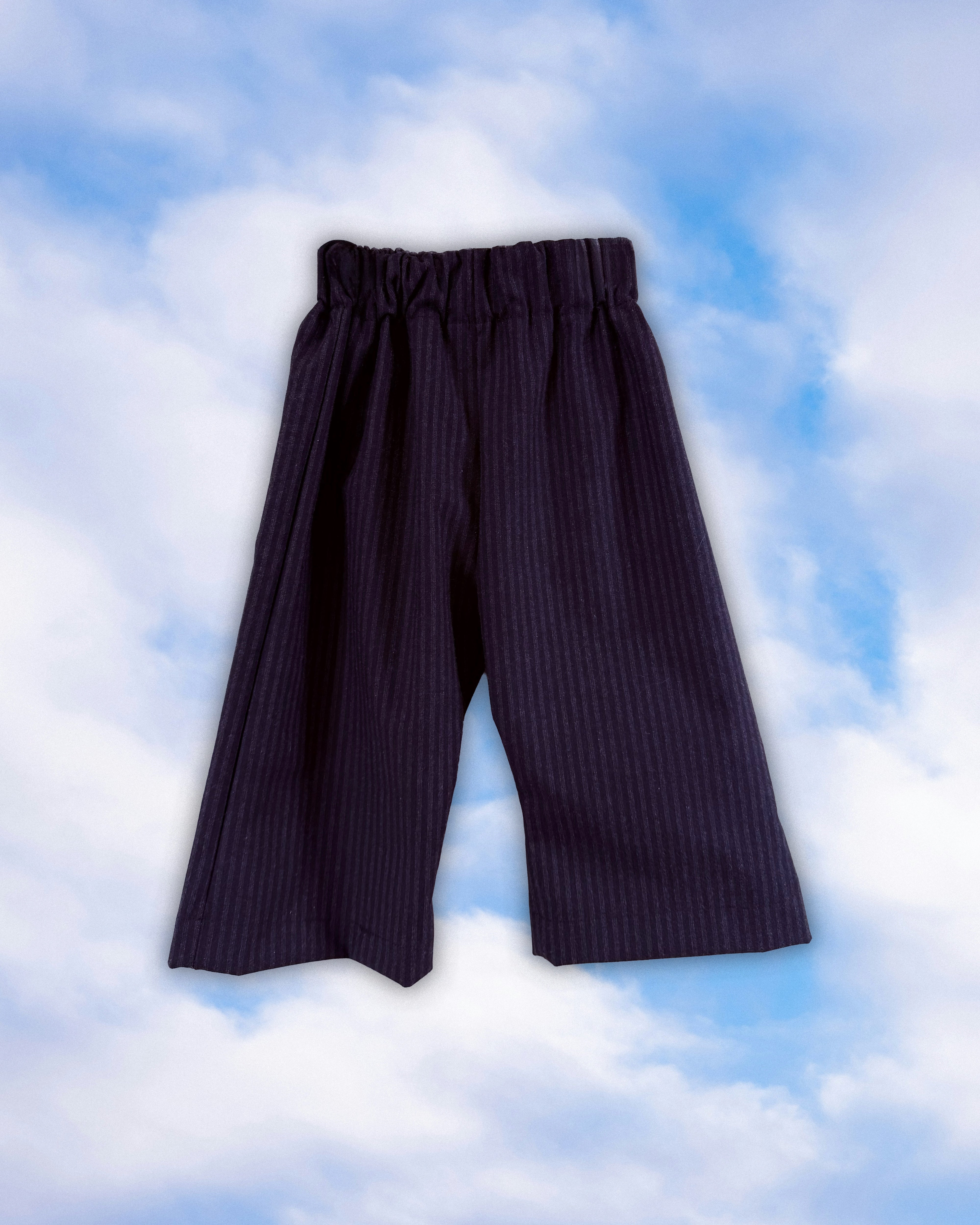 Sample dark pinstripe children’s pull-on pants with an elastic waist on a blue sky background