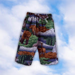 Sample children’s pull-on pants with a woodland bear and deer print on a blue sky background
