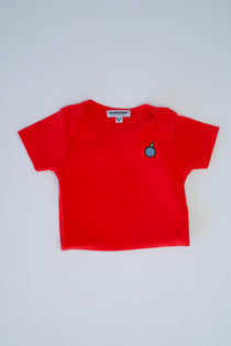 Red short-sleeve baby bodysuit folded to show its blueberry chest emblem.