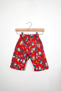 Kids’ pull-on pants in art club red, shown hanging from a wooden hanger.