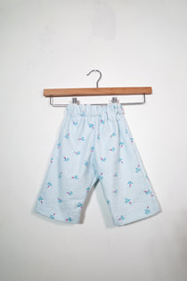 Kids’ pull-on pants in blue rosebud, shown hanging from a wooden hanger.