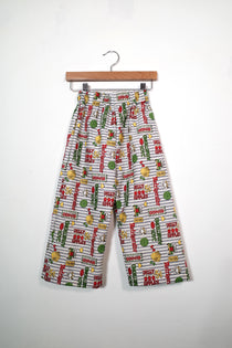 Kids’ pull-on pants in carnival tickets, shown hanging from a wooden hanger.
