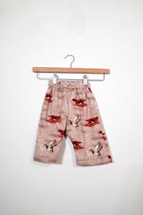 Kids’ pull-on pants in ducks & dogs, shown hanging from a wooden hanger.