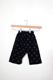 Kids’ pull-on pants in starry night, shown hanging from a wooden hanger.