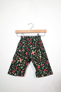 Kids’ pull-on pants in woodland floral, shown hanging from a wooden hanger.